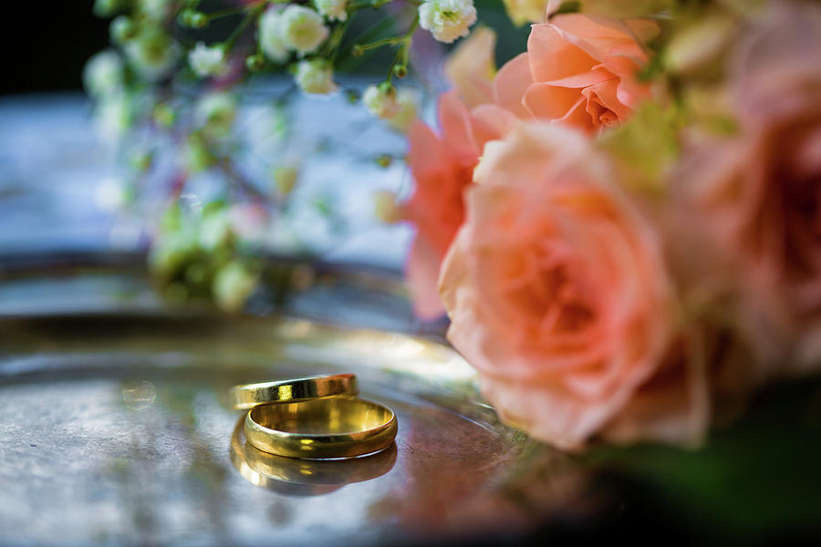 Premium Photo | Gold wedding rings on a bouquet of flowers for the bride