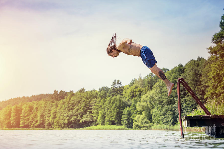Young fit man jumping into a lake #2 Photograph by Michal Bednarek