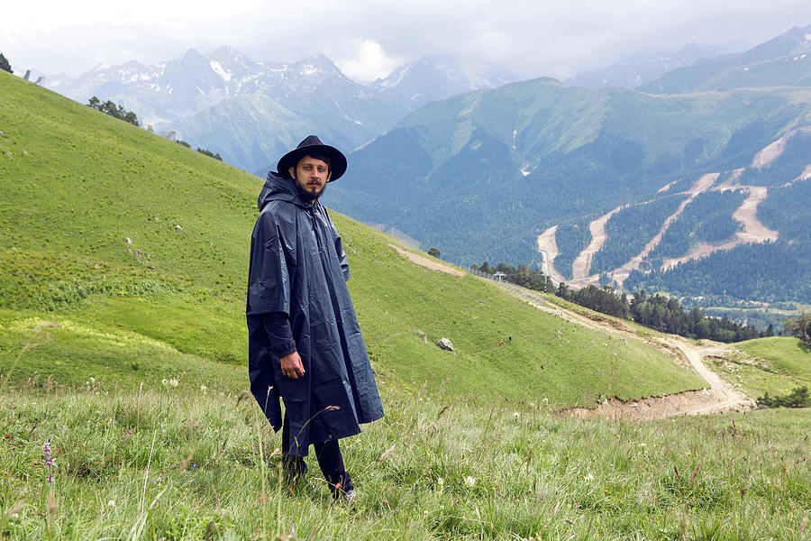 Nature Photograph - Man With A Beard Shepherd Standing In The Mountains In A Black Raincoat #4 by Elena Saulich