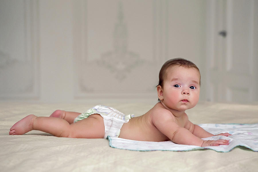 Baby Girl Lying On The Bed Photograph