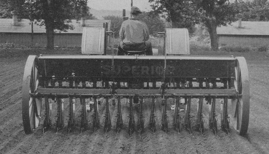 Black And White Photograph - A Farmer Driving A Tractor by American School