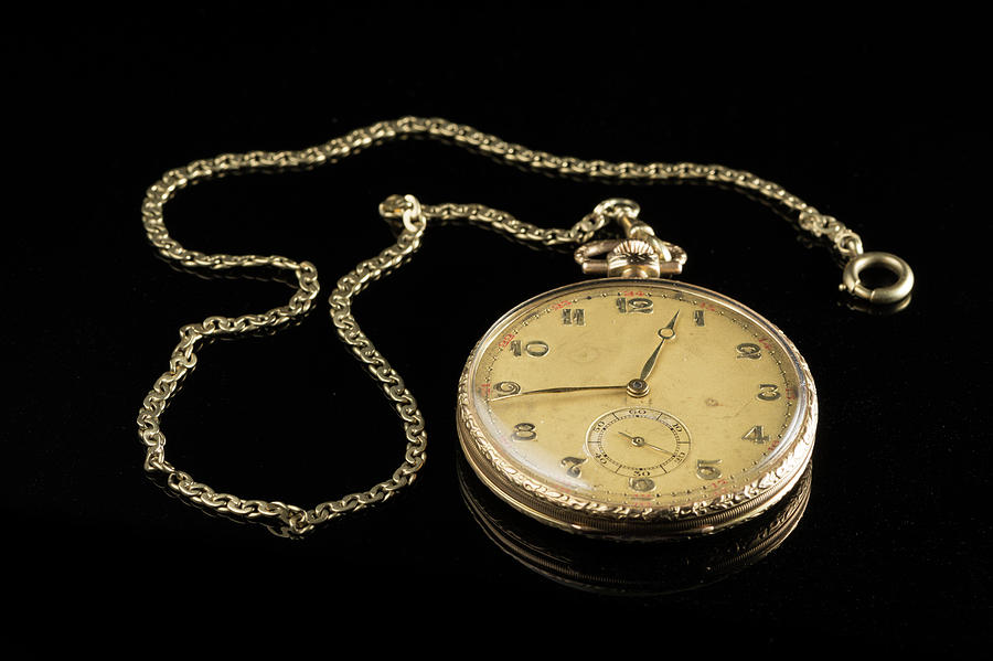 Old golden pocket watch on a black reflective surface Photograph by ...