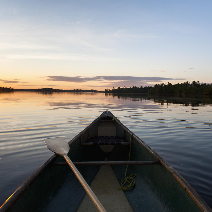 A Boat And Paddle On A Tranquil Lake Photograph by Keith Levit