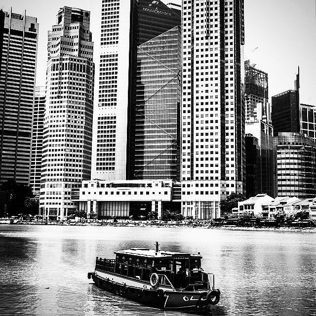 Architecture Photograph - A Boat Travels Through Singapore by Aleck Cartwright
