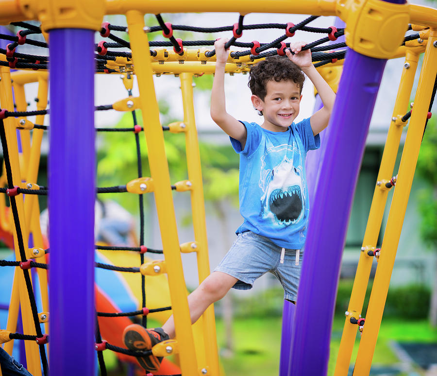 A boy climb a rope in playground in preschool Photograph by Anek ...