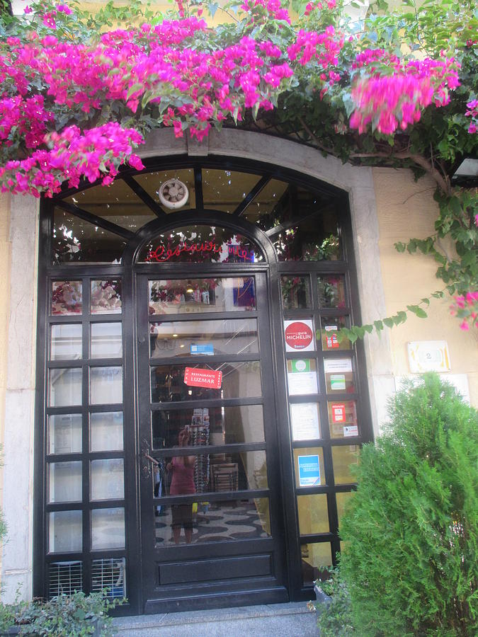 Flower Photograph - A door of a restaurant in Cascais with violet flowers by Anamarija Marinovic