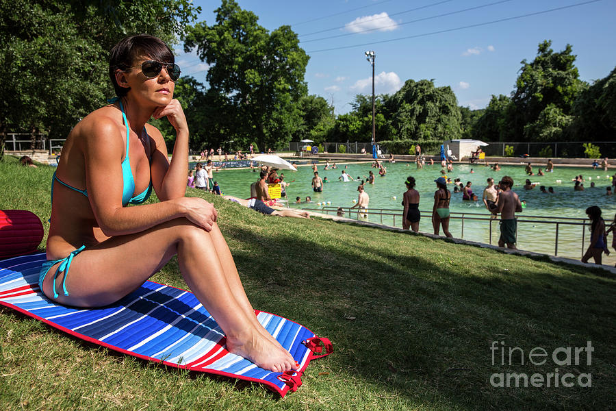 Austin Photograph - A fit Austin woman sunbathes in a bikini at Deep Eddy Pool, surrounded by grassy slopes which are the best in Austin for sunbathing by Dan Herron