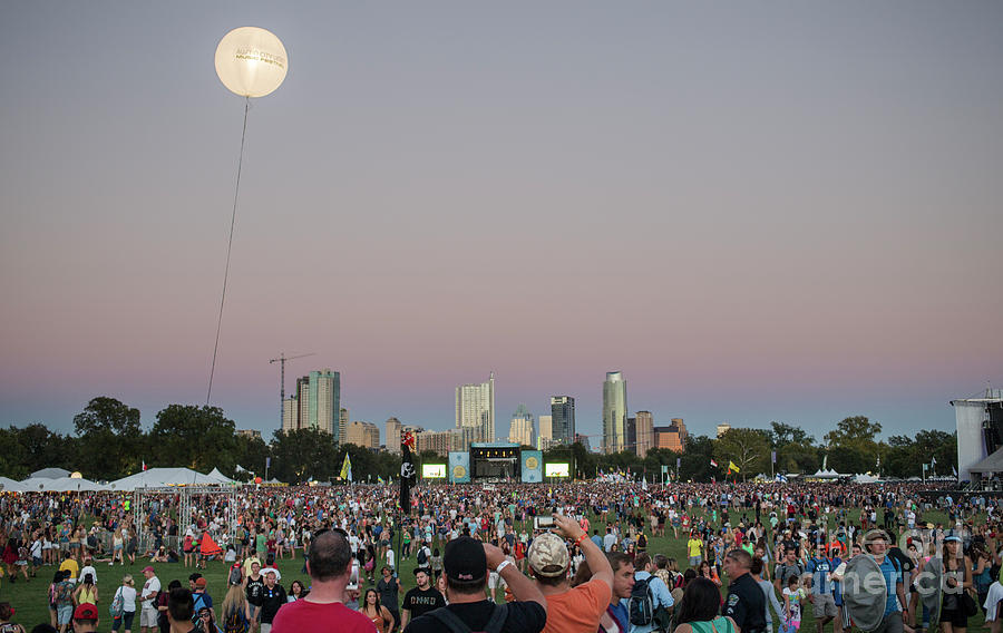 Austin City Limits Photograph - A giant ACL helium ballon lights up the night sky during the Austin City Limits Music Festival overlooking the Austin skyline on October 12, 2014. by Herronstock Prints