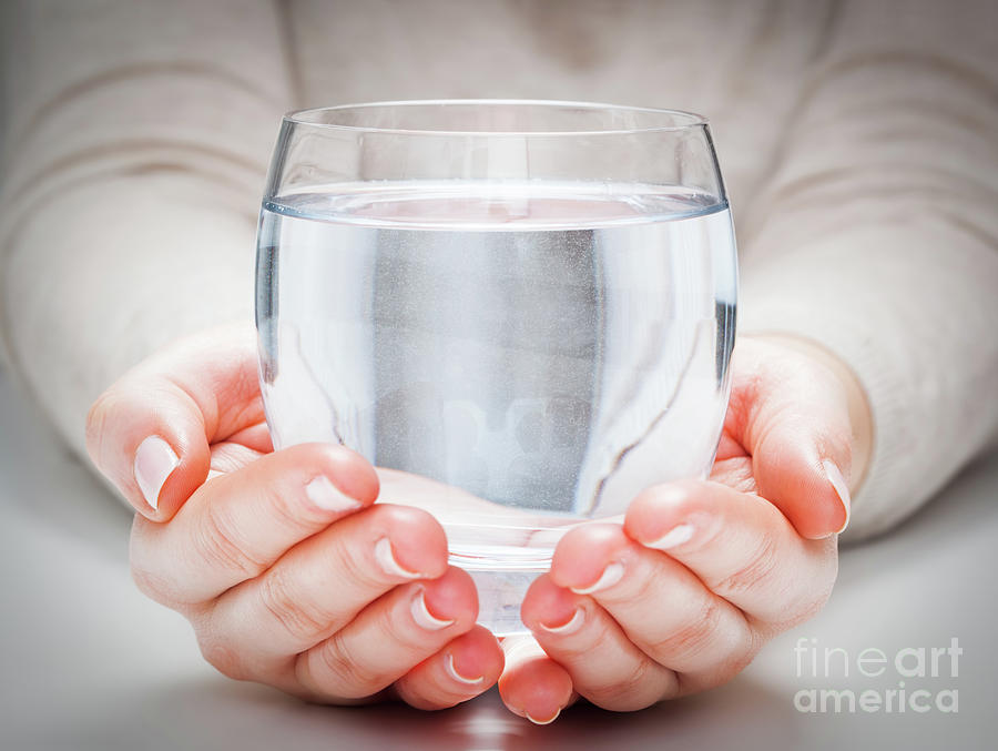 A glass of clean mineral water in womans hands. Environment protection, healthy drink Photograph by Michal Bednarek