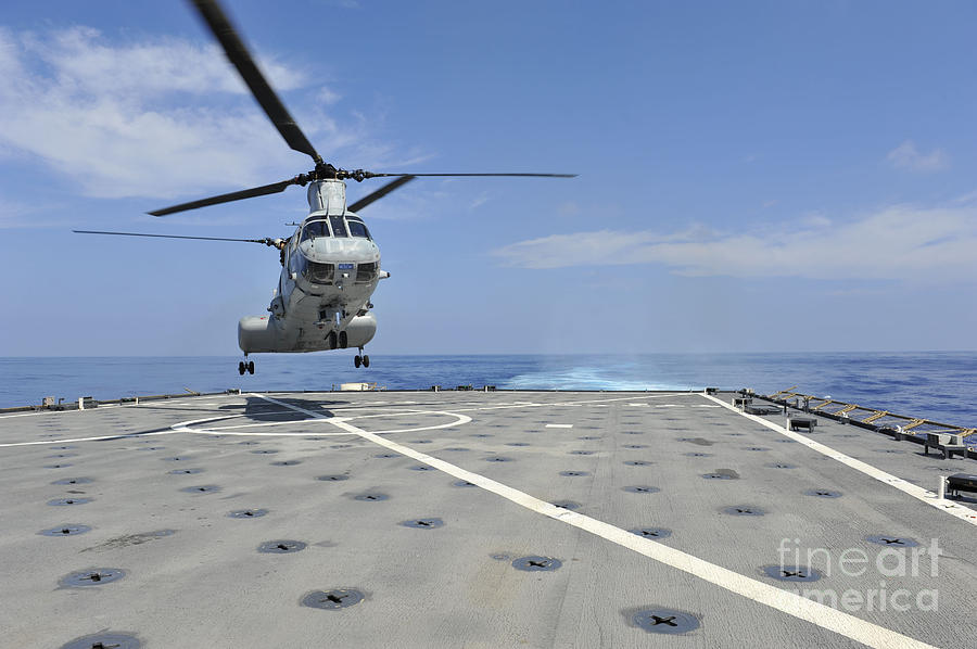 A helicopter lands on the deck of USS Pearl Harbor. Painting by Celestial Images