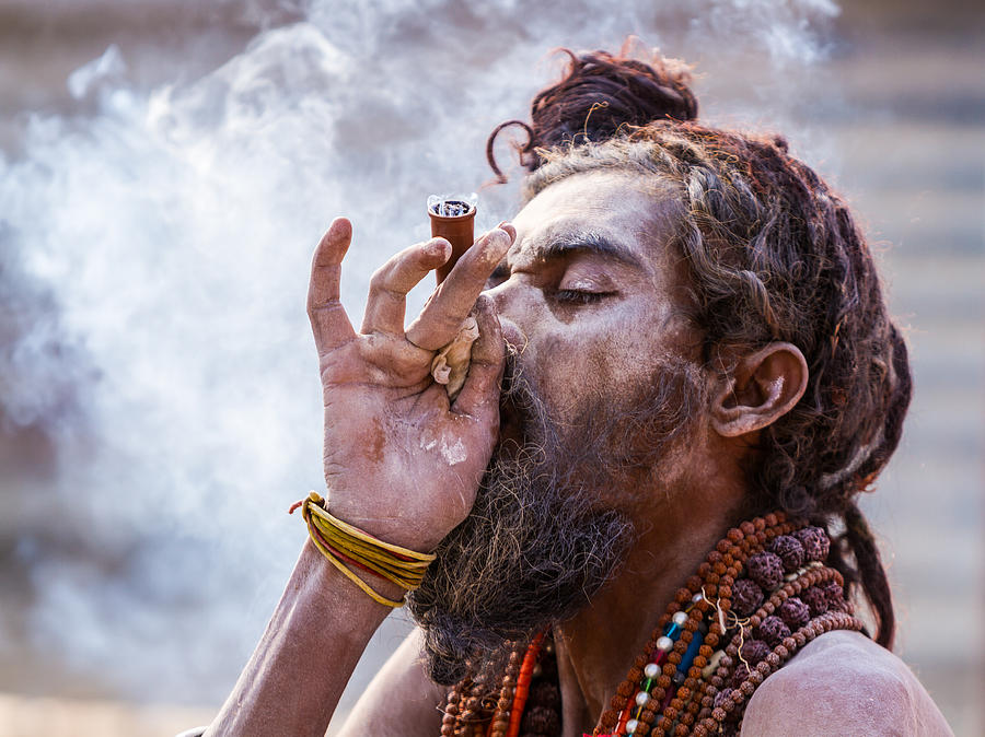 Portrait Photograph - A Hindu sadhu smoking a hash pipe - India. by Nila Newsom
