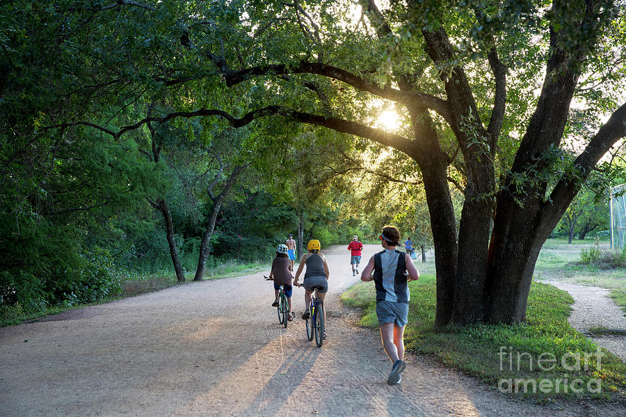 Nature Photograph - A late afternoon sunset greets runners and bikers on the Lady Bird Lake Hike and Bike Trail in downtown Austin by Dan Herron