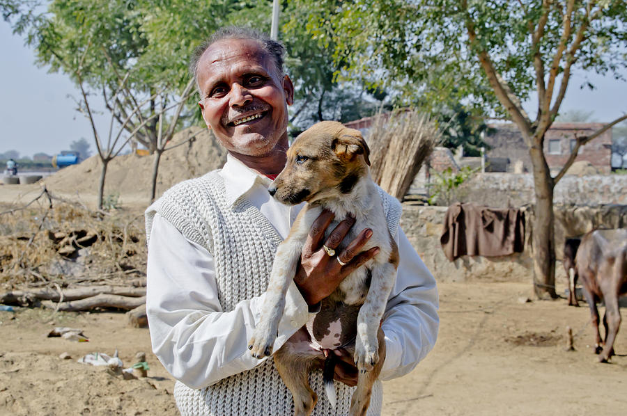 A man with a puppy at the roadside. Photograph by Elena Perelman