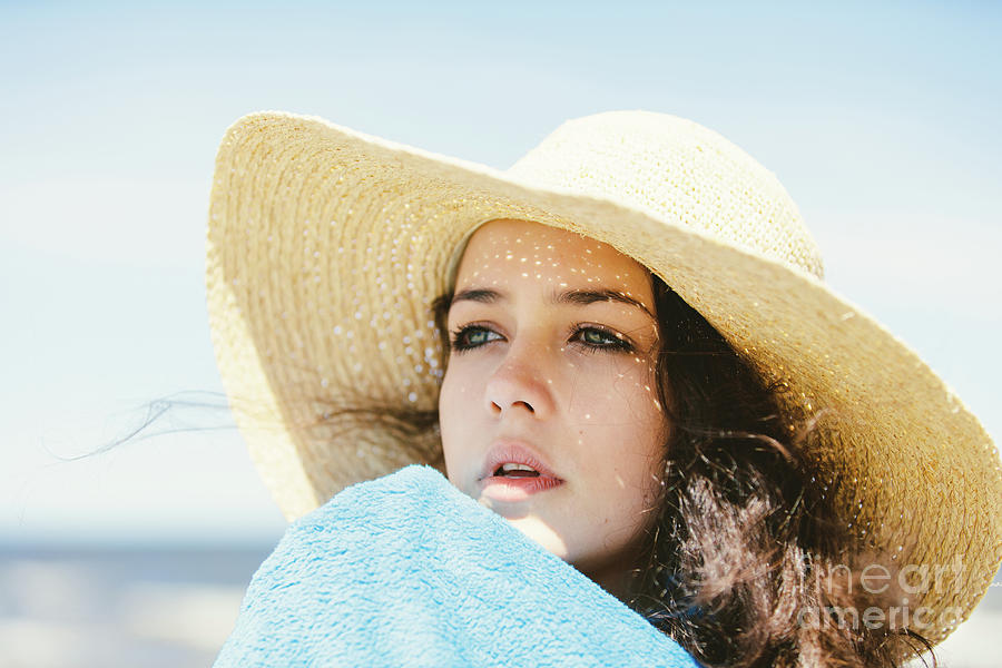 A portrait of a young girl in a straw hat. Photograph by Michal Bednarek