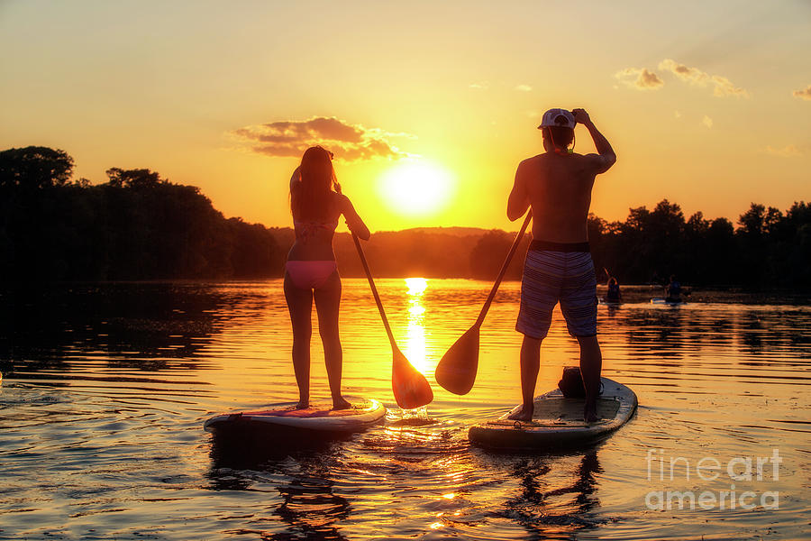 Silhouette Photograph - A silhouette of a couple on a stand-up paddle boards SUP at sunset on Lady Bird Lake in Austin Texas by Dan Herron