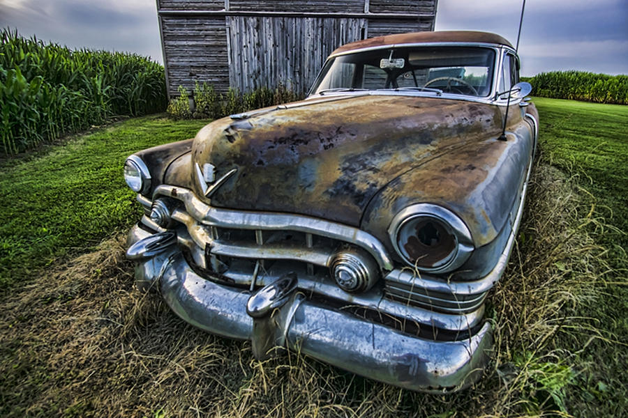 A stylized wide angle look at an old rusty cadillac by a cornfield Photograph by Sven Brogren