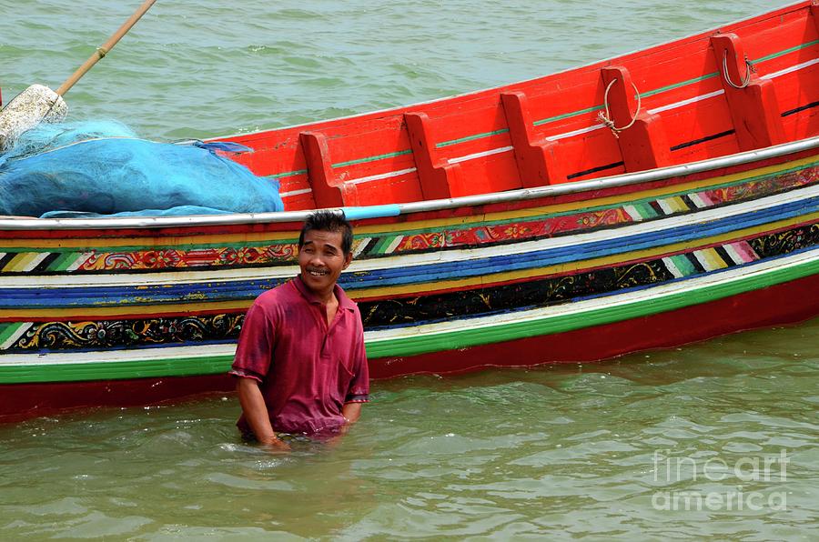 A Thai fisherman stands in water by his boat Pattani Thailand Photograph by Imran Ahmed