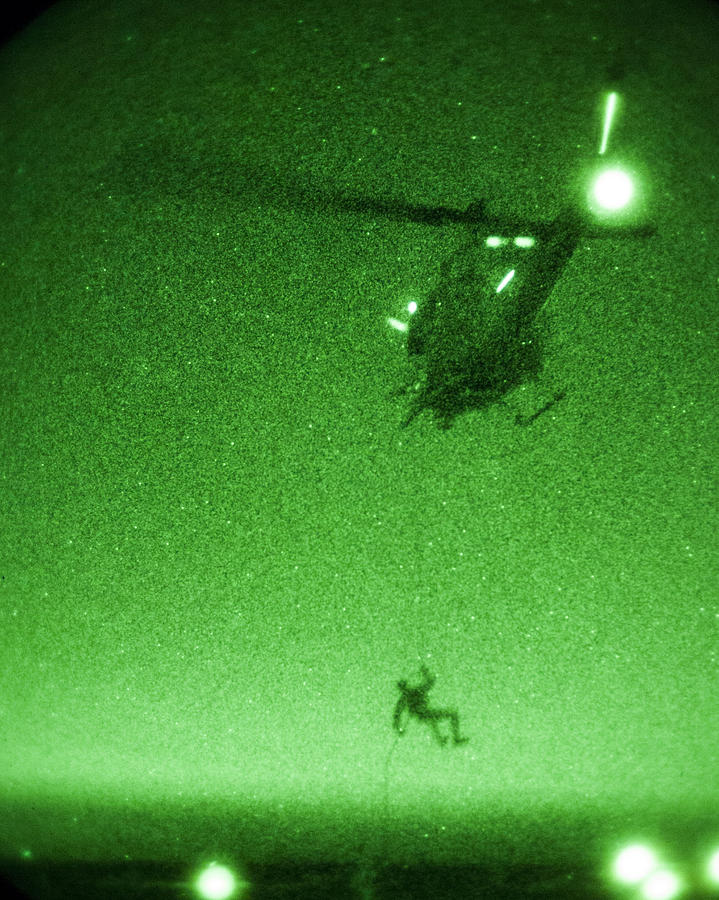 A U.S. Marine rappels from a UH-1N Huey helicopter Photograph by Celestial Images