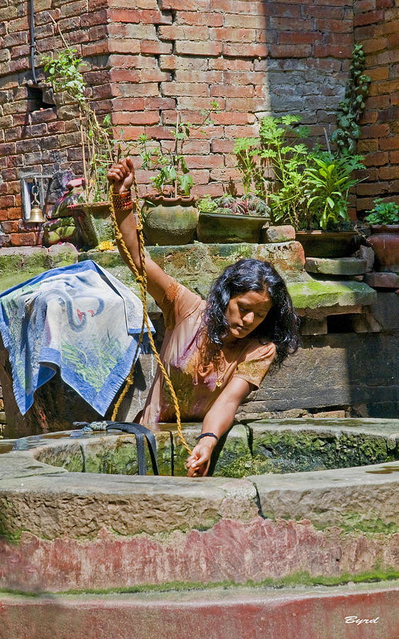 A woman draws water at a well in Bhaktapur Nepal Photograph by Christopher Byrd