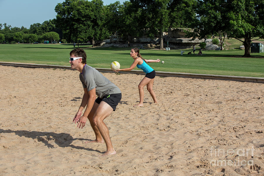 Spring Photograph - A young attractive female serves volleyball on Zilker Park sand volleyball courts by Dan Herron
