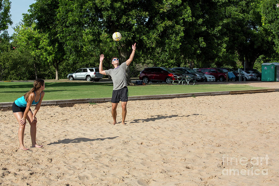 Spring Photograph - A young male athlete serving and playing volleyball on Zilker Park sand volleyball courts by Dan Herron