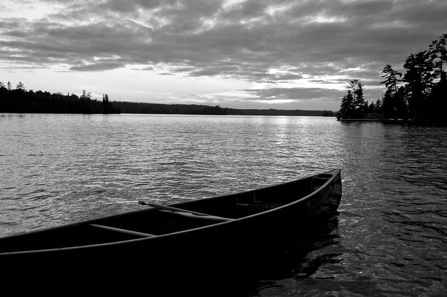 Black And White Photograph - Abandoned Canoe Floating On Water by Keith Levit
