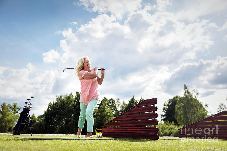 Active senior woman playing golf. Photograph by Michal Bednarek