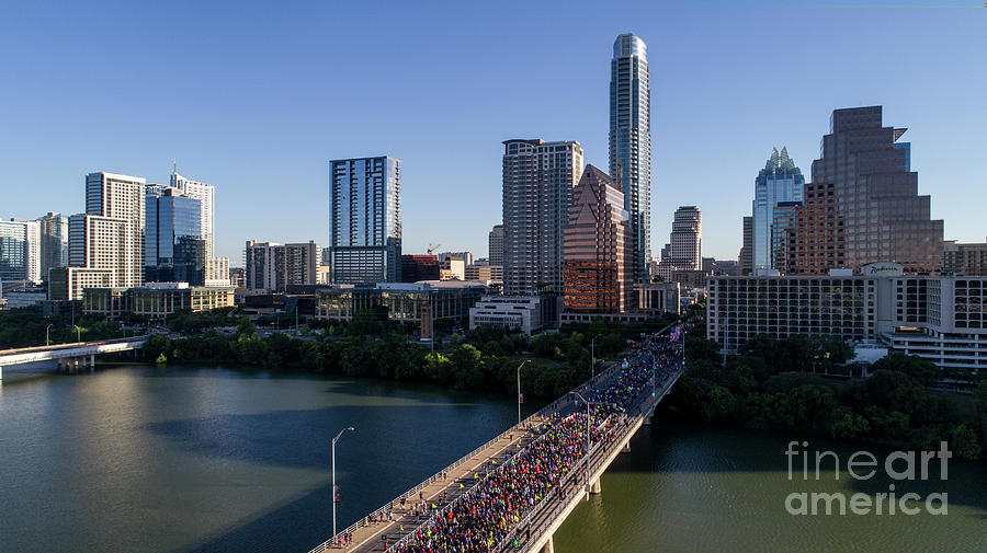 Austin Photograph - Aerial view as thousands of runners take start the race on the Congress Avenue Bridge during the Statesman Cap10K in downtown Austin Texas by Dan Herron