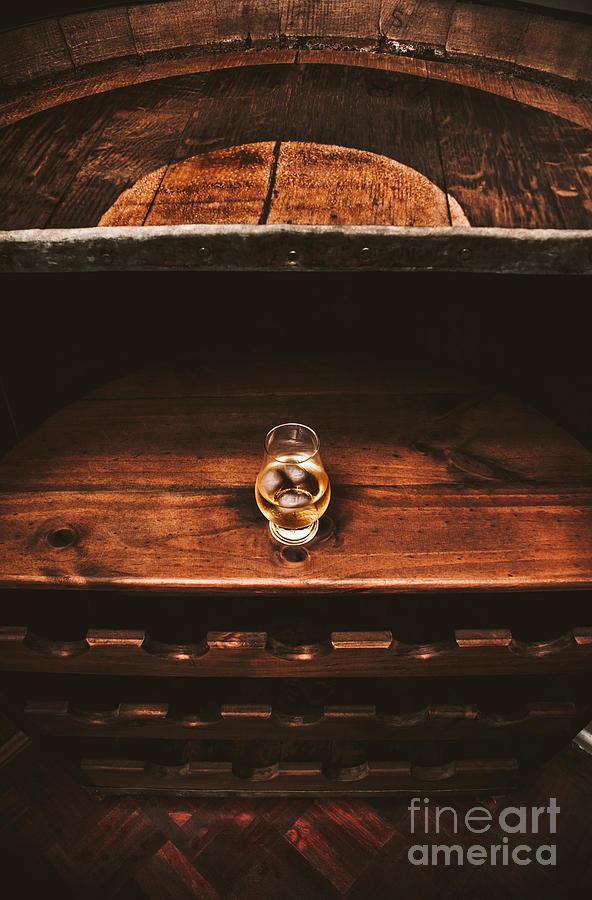 Aged glass of rum on cellar barrel Photograph by Jorgo Photography