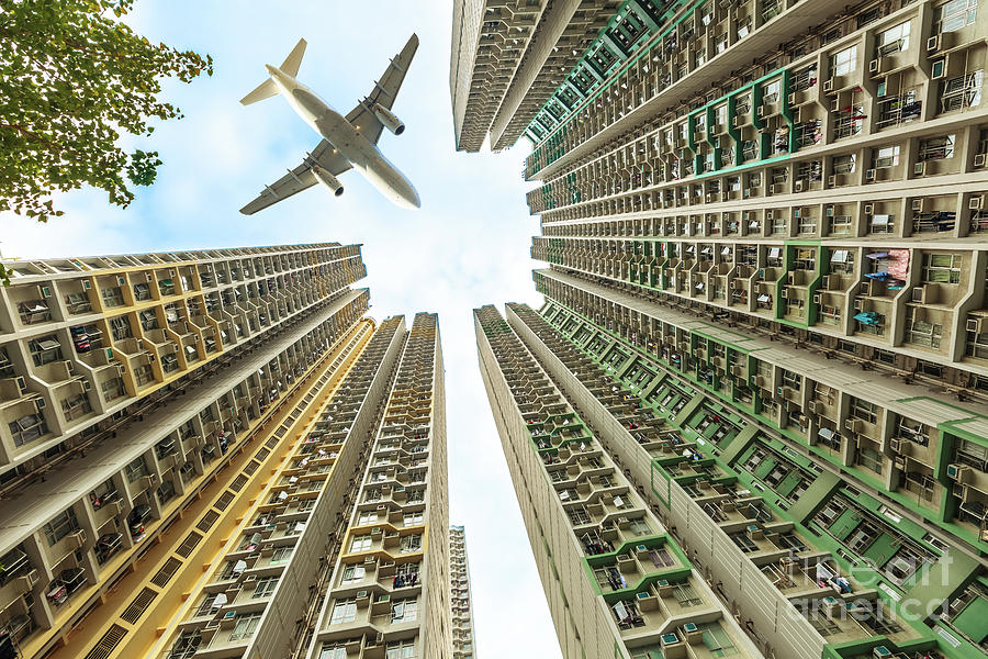 Airplane above residential district Photograph by Benny Marty