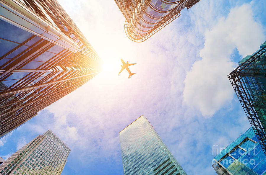 Transportation Photograph - Airplane flying over modern business skyscrapers by Michal Bednarek