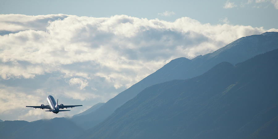 Airplane taking off over the alpine mountains Photograph by Ian Middleton
