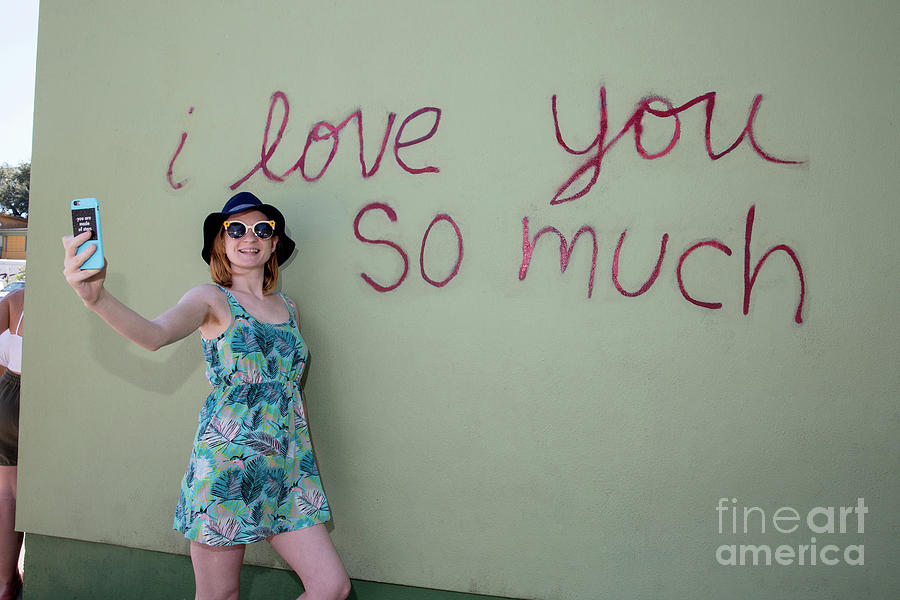 Austin Photograph - An Austin local takes a selfie at the famous I love you so much  by Dan Herron