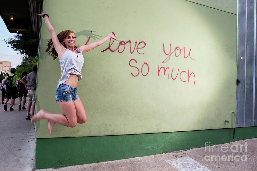 Austin Photograph - An Austin local woman jumps for joy at the i love you so much mu by Dan Herron