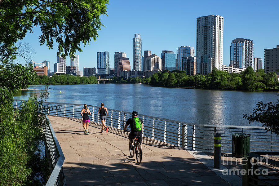 Austin Skyline Photograph - An early morning sunrise greets runners and bikers on the Boardwalk Trail part of the Lady Bird Lake Hike and Bike Trail in downtown Austin, Texas by Dan Herron