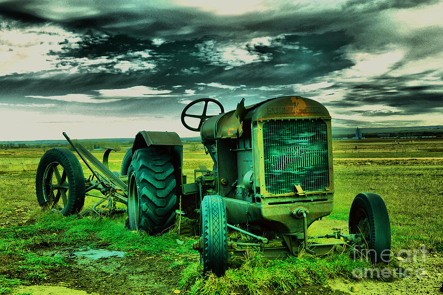 An old tractor bereft in a field Photograph by Jeff Swan