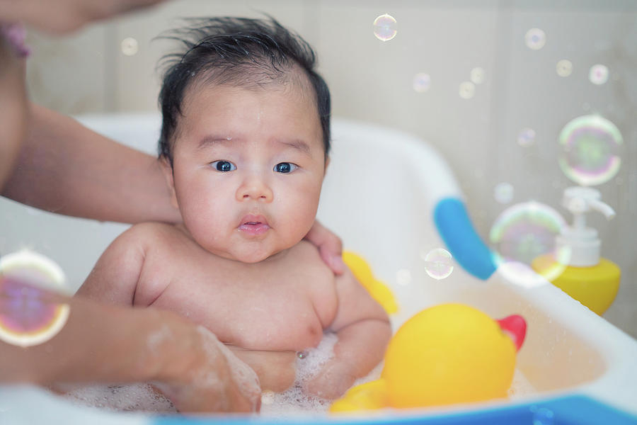 Asian baby bath with mother Photograph by Anek Suwannaphoom