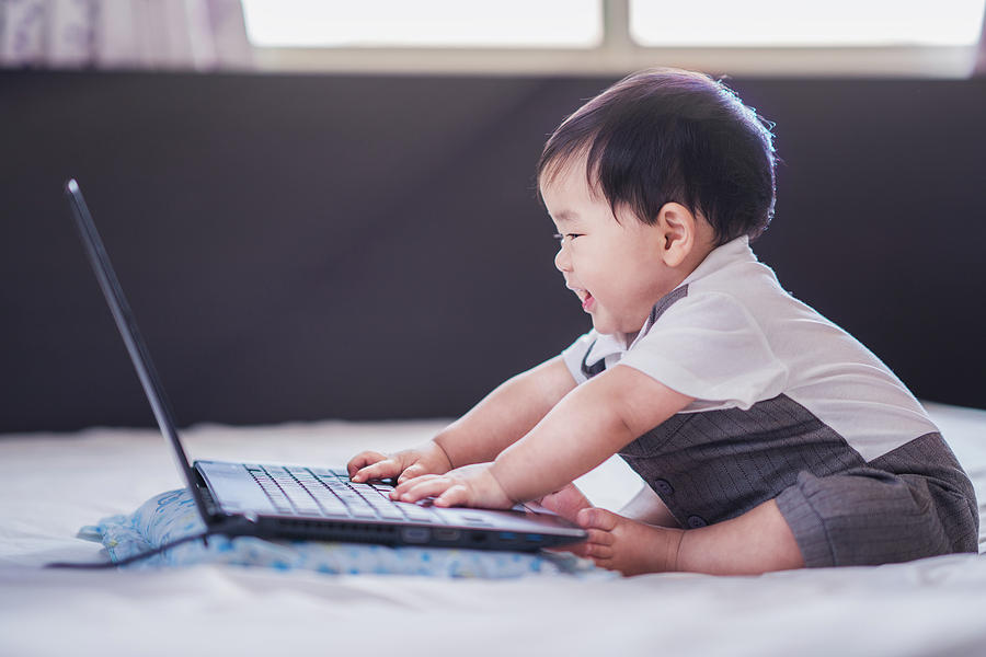 Asian baby in business suite sit and play computer notebook Photograph by Anek Suwannaphoom