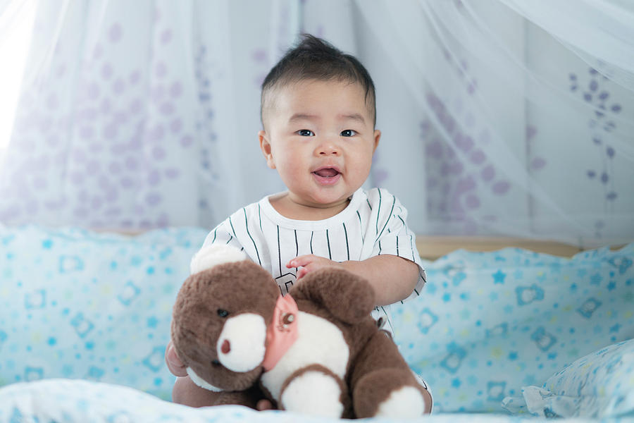 Asian baby play a teddy bear Photograph by Anek Suwannaphoom