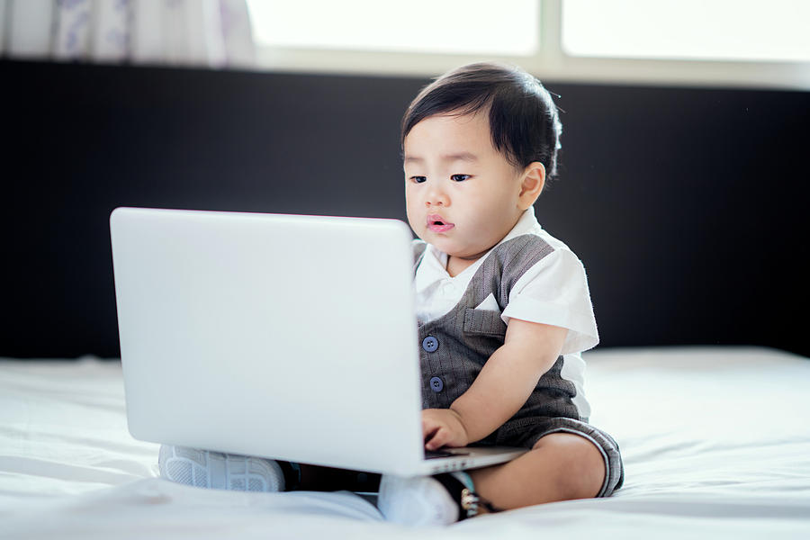 Asian baby sit in working action with business uniform  Photograph by Anek Suwannaphoom