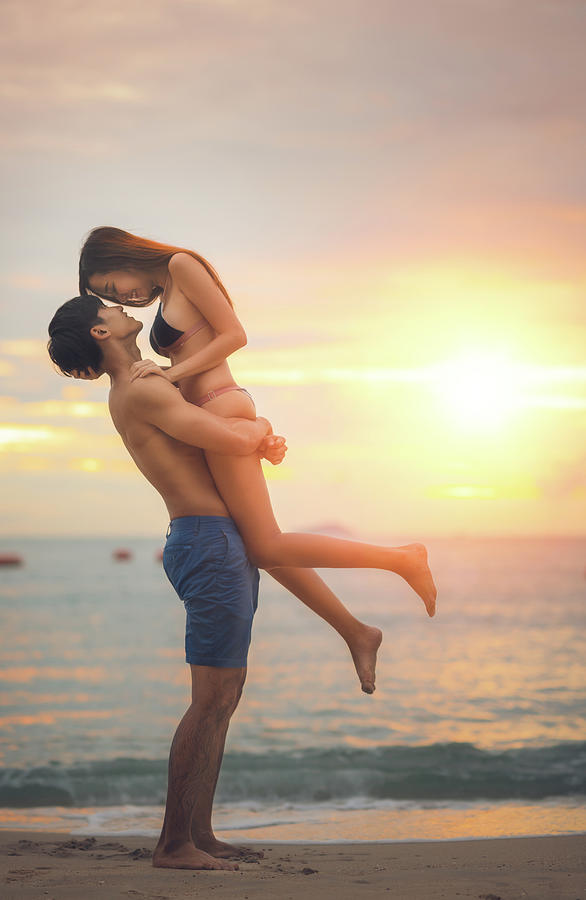 Asian couple run togather on the beach between honeymoon  Photograph by Anek Suwannaphoom