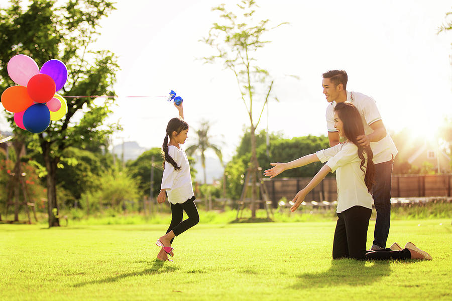 Asian family run and play in a garden Photograph by Anek Suwannaphoom
