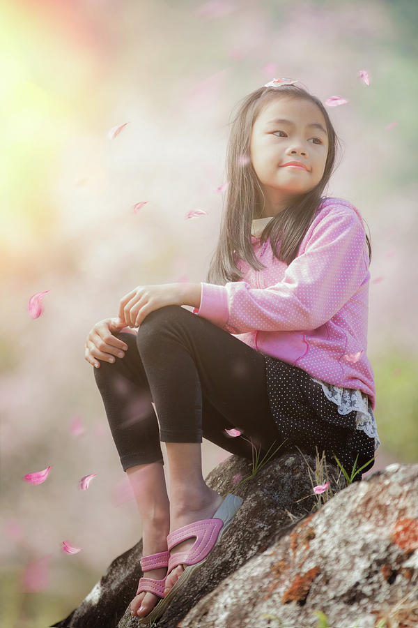 Asian girl sit and relax with Sakura fall Photograph by Anek Suwannaphoom