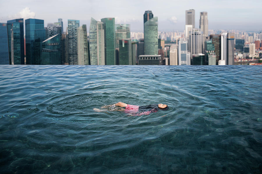 Asian girl swimimg in the roof top swimming pool in Hotel Photograph by Anek Suwannaphoom