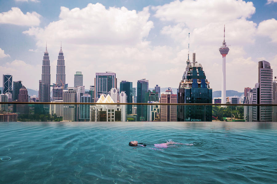 Asian girl swimming in roof top swimming pool in hotel Photograph by Anek Suwannaphoom