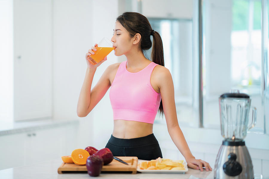 Asian lady in fitness sport wear drink a mix fruit and vegetable Photograph by Anek Suwannaphoom