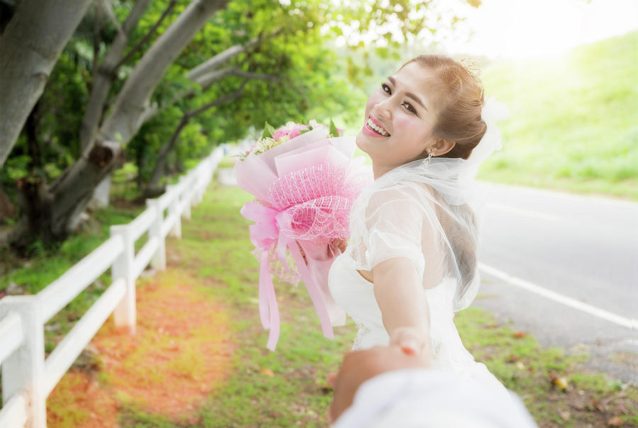 Asian lady in wedding dress run Photograph by Anek Suwannaphoom