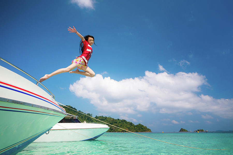 Asian lady jump and fly to sky between travel the Thailand sea Photograph by Anek Suwannaphoom