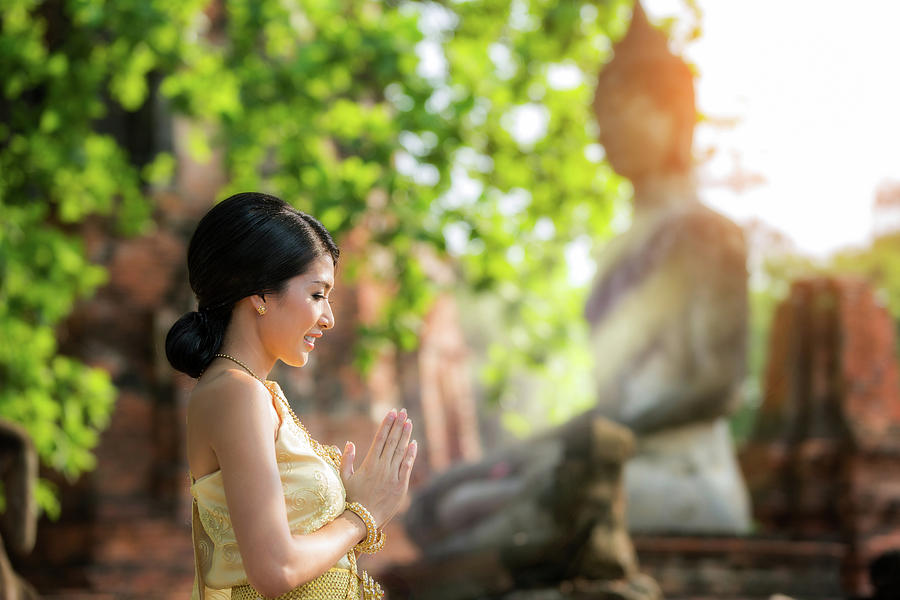 Buddha Photograph - Asian lady with with buddha statue in background by Anek Suwannaphoom