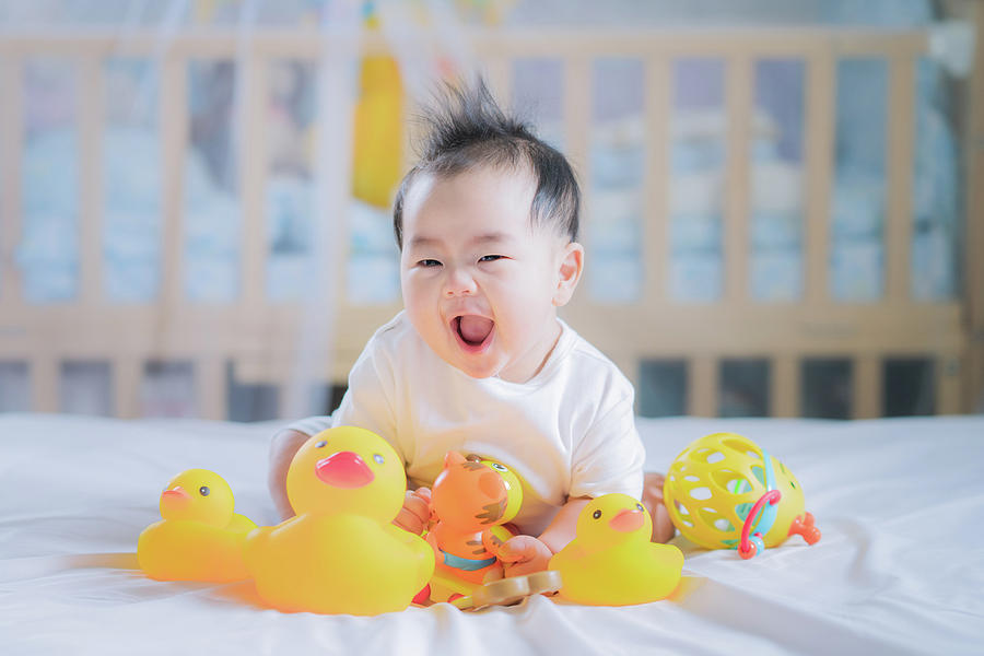 Asian New born baby sit and play an animal toy Photograph by Anek Suwannaphoom